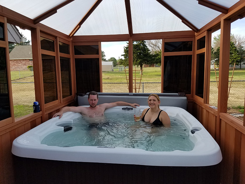 a couple on a hot tub inside a gazebo