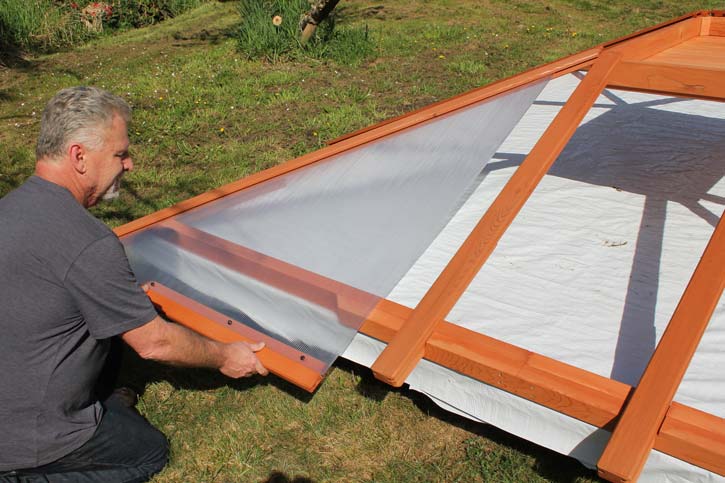 a man installing a hot tub enclosure roof panel