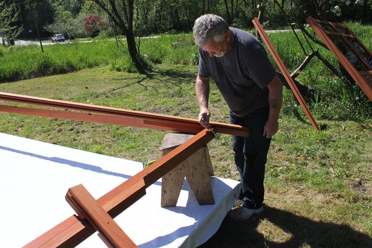 a man assembling a gazebo roof