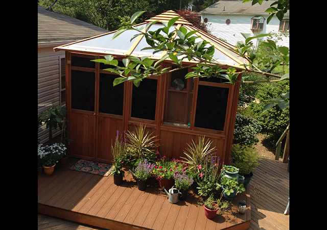 a Solarus gazebo with transparent roof on top of a wooden deck